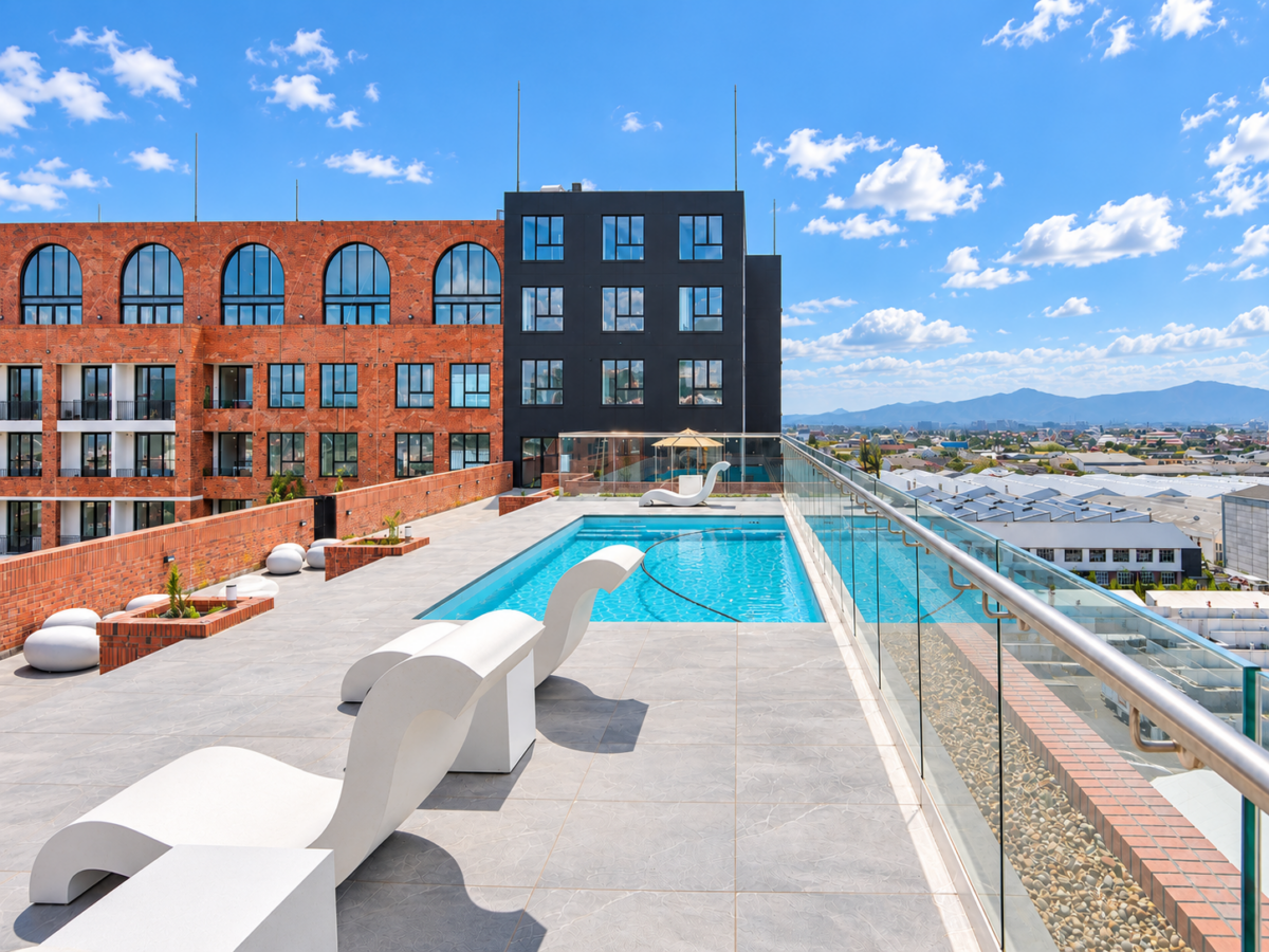 Rooftop swimming pool and sun loungers beside the brick building
