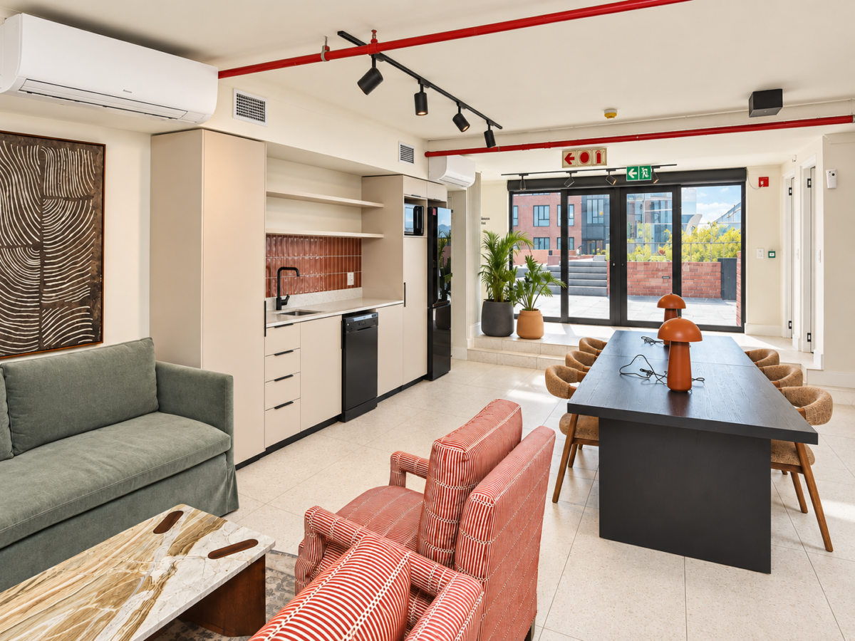 Shared lounge with comfortable seating, a communal table and kitchenette
